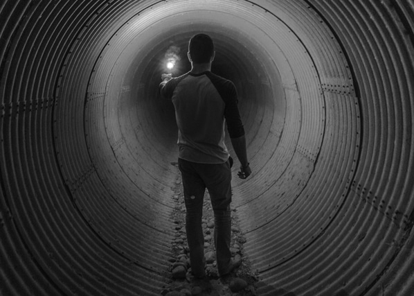 Artistic image of a man lighting a match in a tunnel representing a metaphor for lighting a path out of addiction with the help of therapists at MindSol Wellness Center in Sarasota, Florida
