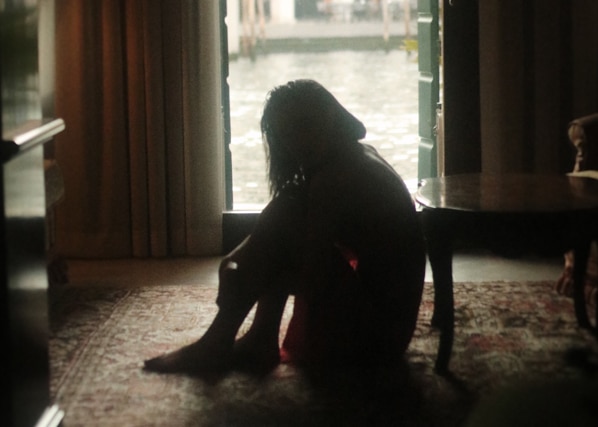 Depressed woman staring out the door into the rain considering therapy at MindSol Wellness Center in Sarasota, Florida