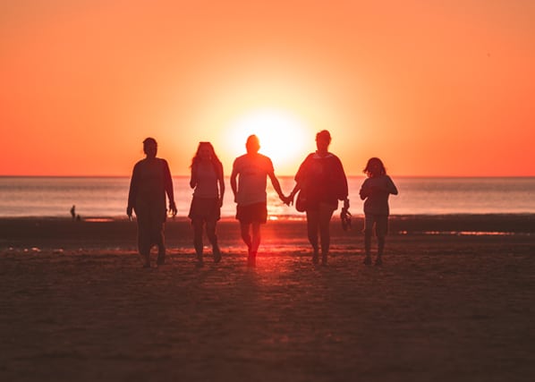Family walking toward the sunset at Siesta Key Beach In Sarasota County