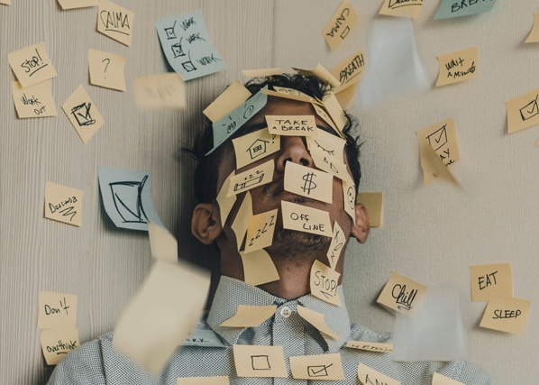 Man with sticky notes all over his face and body implying his overwhelming responsibilities and inability to practice stress management techniques learned at MindSol Wellness Center in Sarasota, Florida