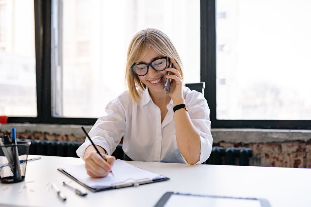 A care coordinator smiling on the phone while scheduling an appointment
