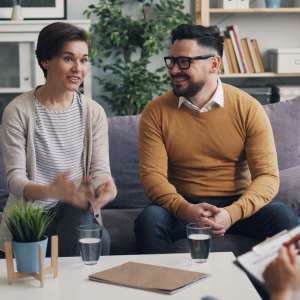 A couple talking with a counselor during a session in a bright room