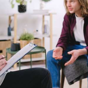 A man talking with a therapist who takes notes during a counseling session